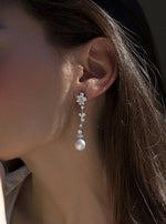 Long bridal earrings with zircons and finished with a pearl in floral motifs